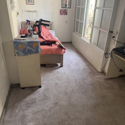 בקבוק תרסיס על שולחן, שואב אבק על מיטה