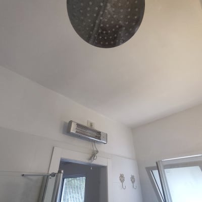 תקרה צבועה בלבן עם גוף תאורה עגול