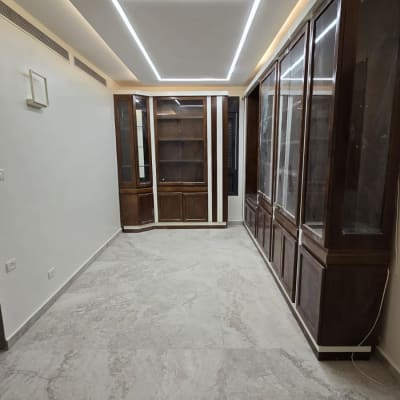 ארונות עץ מותקנים בחדר עם תאורת תקרה מודרנית