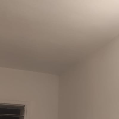 קיר ותקרה צבועים בלבן עם חלון קטן