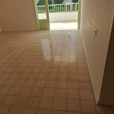 רצפה נקייה ומבריקה בחדר ריק עם דלת פתוחה למרפסת