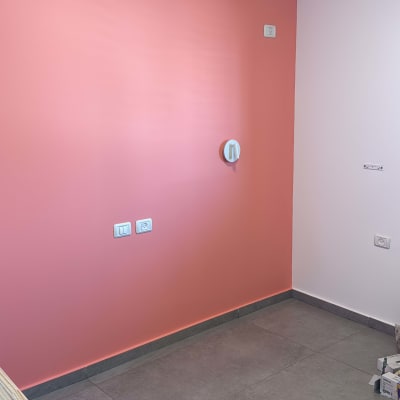 קיר צבוע בצבע ורוד עם שקעים חשמליים
