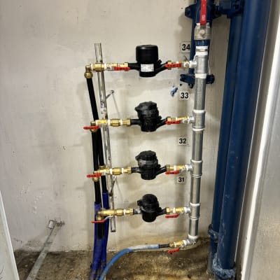 צנרת מים עם ברזים ומדי מים על קיר