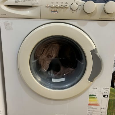 מכונת כביסה עם בגדים בתוף ותווית אנרגיה