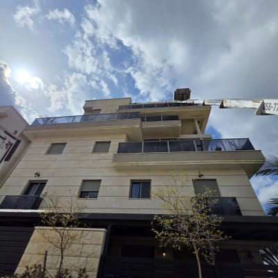 מנוף ליד בניין מגורים עם שמיים מעוננים