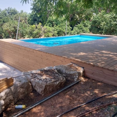 בריכת עץ בגינה עם דק עץ מסביב