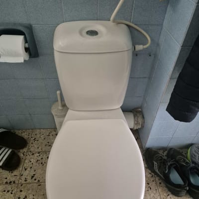 אסלה עם צינור מים מחובר לקיר