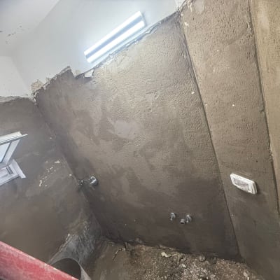 קיר בטון עם חלון פתוח ועבודות שיפוץ