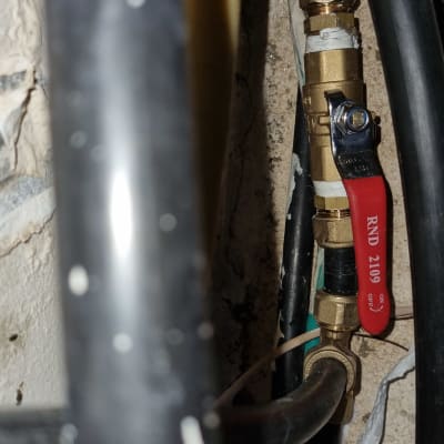 שסתום פליז עם ידית אדומה בצנרת מים