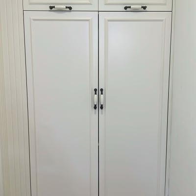 ארון עץ לבן עם ידיות מתכת כהות