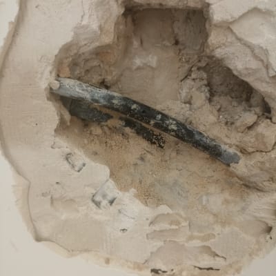 צינור חשוף בקיר עם טיח מתפורר