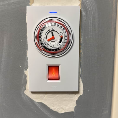 שעון טיימר חשמלי מותקן על קיר אפור