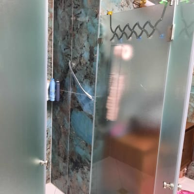 מקלחון זכוכית עם דלתות חלביות ומתקן סבון