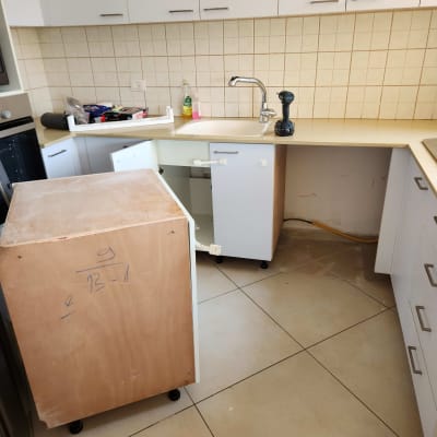 מטבח עם ארונות פתוחים, כיור וכלי עבודה