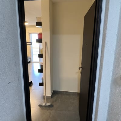 מטאטא עומד ליד קיר צבוע בצבע בהיר