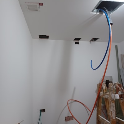 חוטים צבעוניים יוצאים מתקרת גבס במהלך שיפוץ
