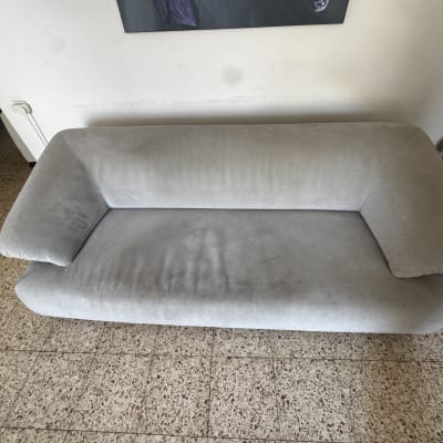 ספה אפורה על רצפת אריחים, ללא אנשים או חפצים נוספים