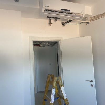 סולם עץ מתחת למזגן מותקן על הקיר