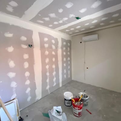 חדר בשיפוץ עם דליי צבע וכלי עבודה על הרצפה