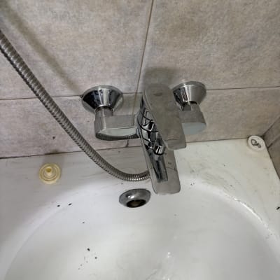 ברז אמבטיה עם צינור מים על קיר אריחים