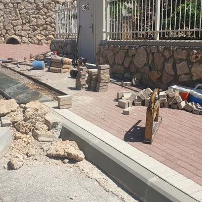 אבנים, בלוקים וכלי עבודה על מדרכה בשיפוצים