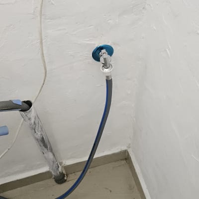 צינור מים מחובר לקיר עם ברז כחול