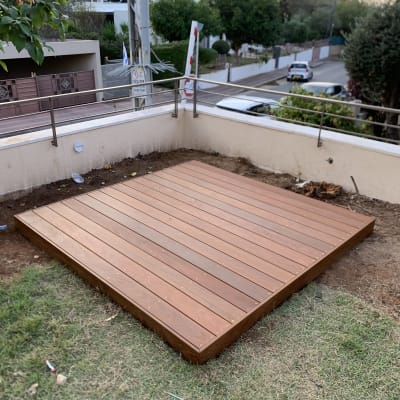 פלטפורמת עץ בגינה עם דשא מסביב