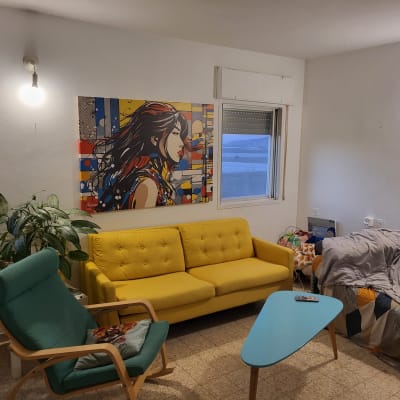 ספה צהובה עם כריות, שולחן קפה קטן