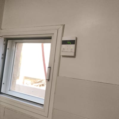 תרמוסטט דיגיטלי מותקן על קיר ליד חלון