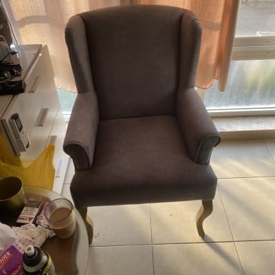 כורסה מרופדת בצבע אפור עם רגלי עץ מעוקלות