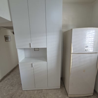 ארון לבן ליד מקרר במטבח