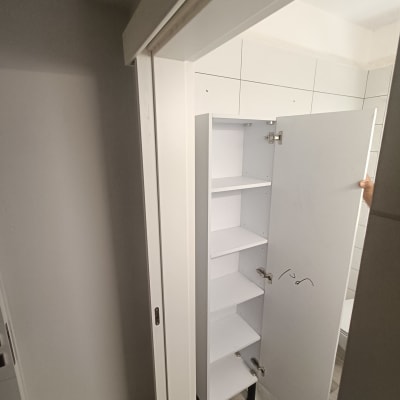 ארון לבן עם דלת פתוחה בחדר אמבטיה