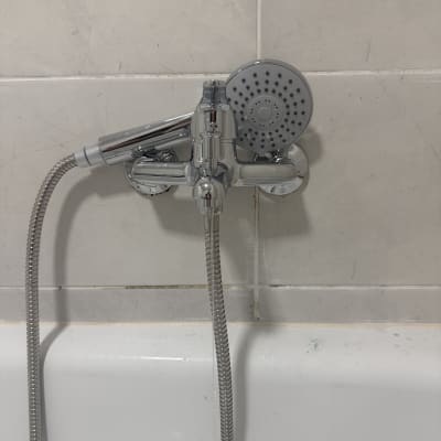 ברז מקלחת עם ראש מקלחת על קיר אריחים