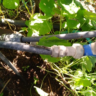 צינורות מחוברים עם מחבר מתכת בגינה