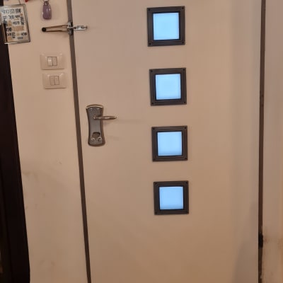 דלת לבנה עם חלונות מרובעים קטנים וידית מתכת