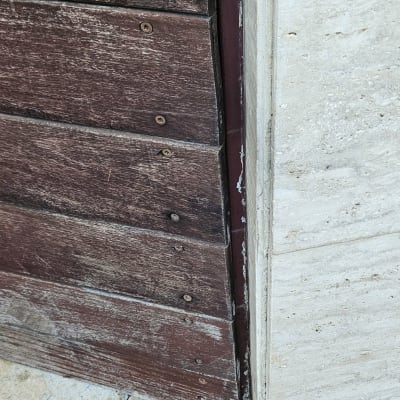 מסגרת עץ עם ברגים על קיר אבן