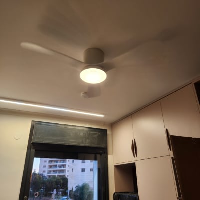 מאוורר תקרה מואר בחדר עם חלון וארונות