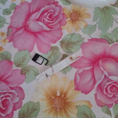 סיכת מתכת ליד כרטיס סים על רקע פרחוני