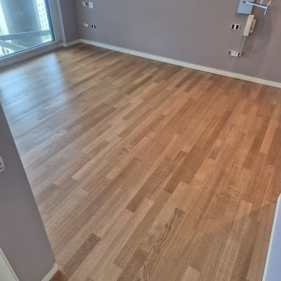 רצפת עץ חדשה בחדר ריק עם קירות סגולים