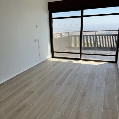 רצפת פרקט חדשה בחדר עם חלון גדול