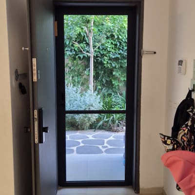דלת פתוחה עם נוף לגינה ירוקה