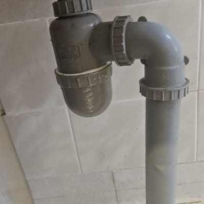 צנרת פלסטיק מתחת לכיור עם קערה מתחת