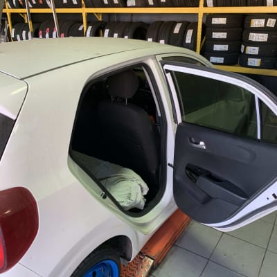 מכונית עם דלת פתוחה ליד מדפי צמיגים