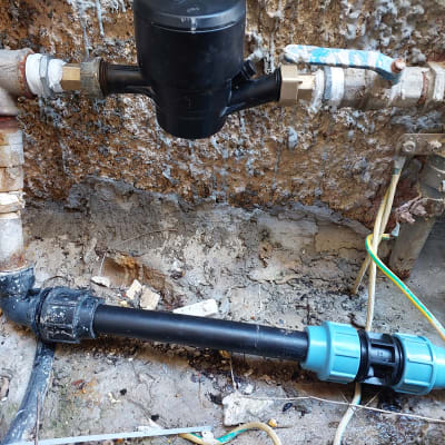 צנרת מים עם מחברים וברזים על קיר