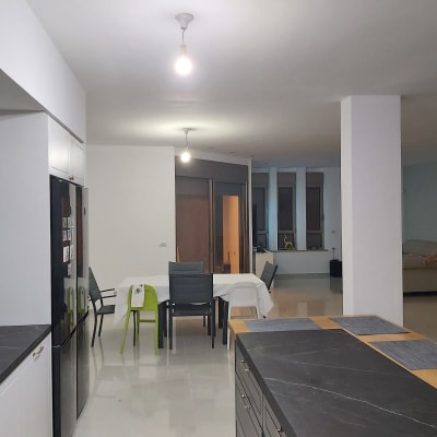 מטבח מודרני עם משטחי עבודה כהים ותאורה חזקה