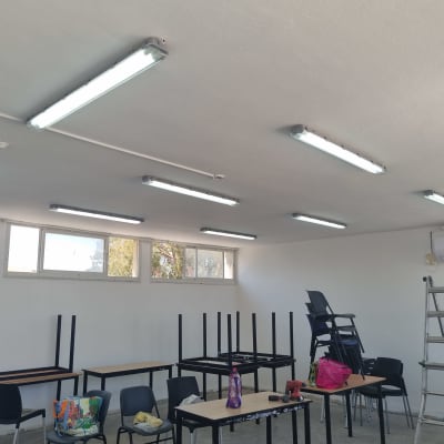 תאורת פלורסנט מותקנת על תקרת חדר עם סולם