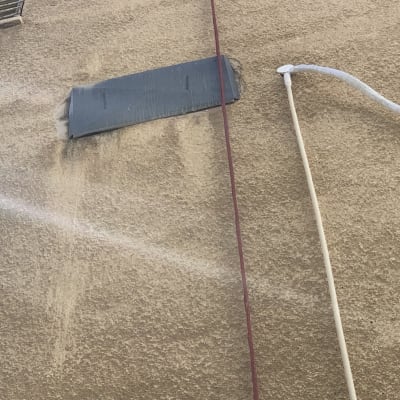 צינור מים מתיז על קיר חיצוני של בניין