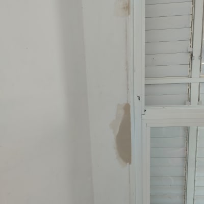 קיר עם תיקוני צבע ליד חלון