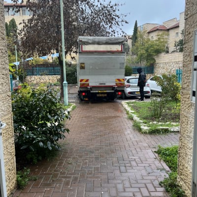 משאית חונה בחצר עם אדם עומד ליד רכב