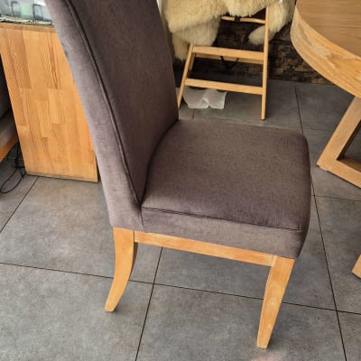 כיסא מרופד עם רגלי עץ על רצפת אריחים